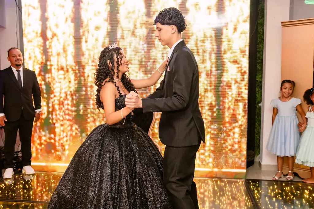 Valsa da debutante com o par, diante do painel de LED dourado